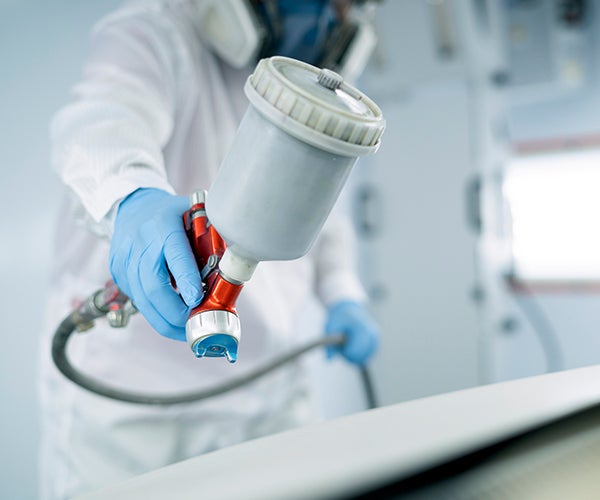 Worker in PPE using spray gun