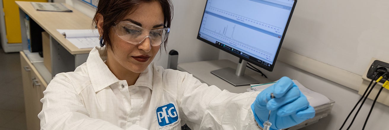 Female PPG employee working in laboratory wearing PPE
