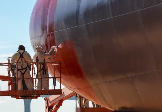 Man spraying side of ship