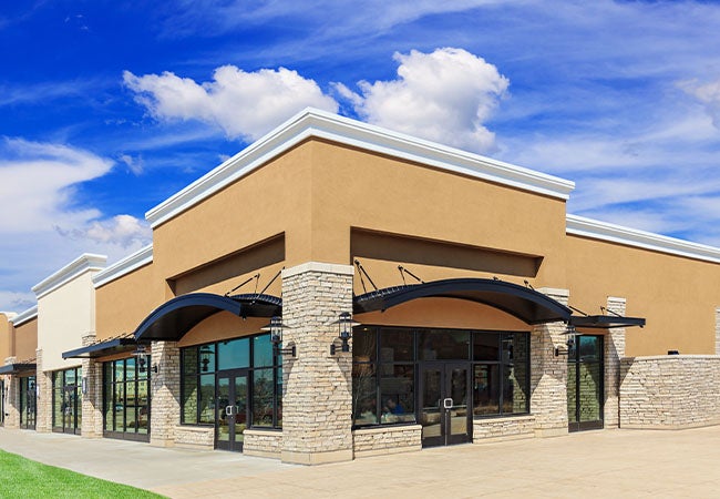 Retail street with corner facing store, brick walls and a beige finish