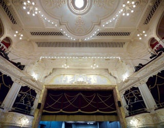 High-angle view of an ornate theatre ceiling featuring detailed carvings, patterns, and architectural embellishments.