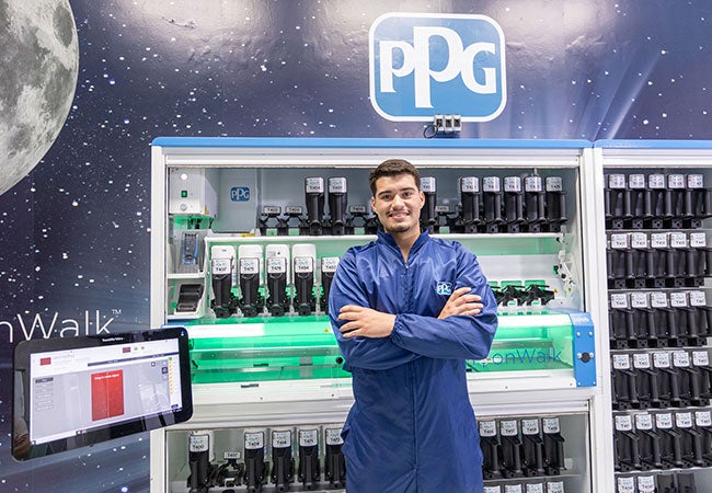 Male worker in PPG overalls standing in front of MoonWalk device