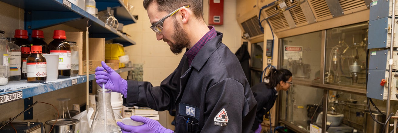 Male worker in lab wearing full PPE