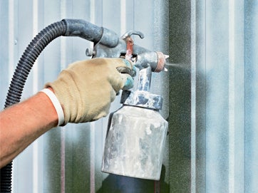 A person spraying a metal object