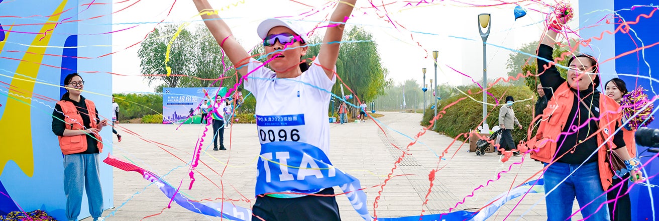 Female employee passing through finish line in running race