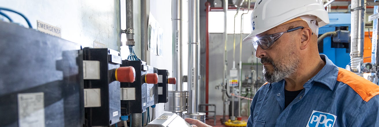 Male worker wearing PPE using machinery