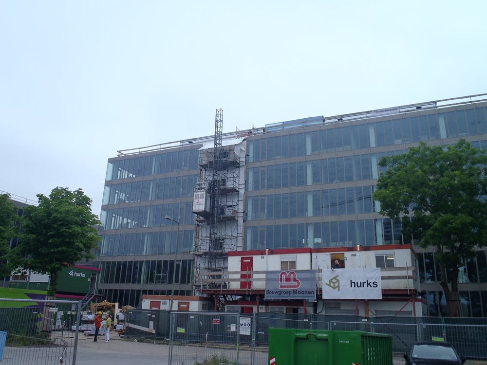 Een gebouw met een steiger en een kraan