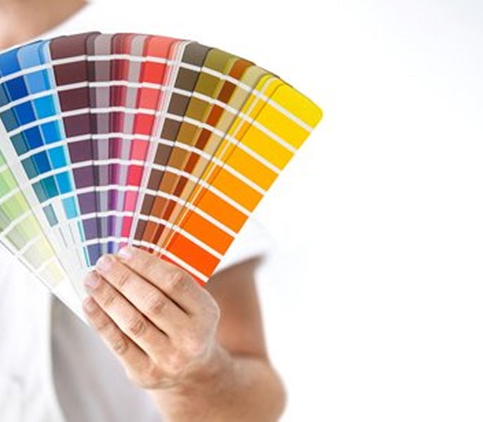 A person holding a fan of color swatches