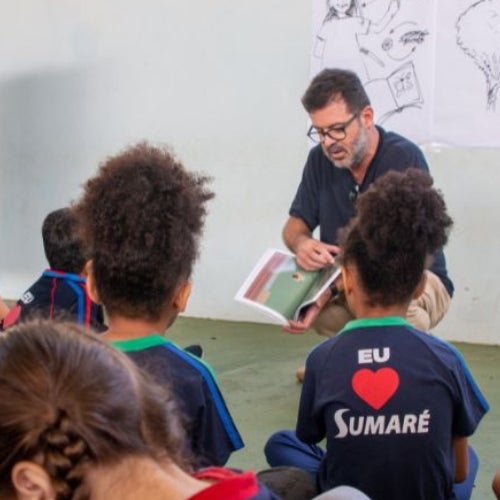 A man reading a book to a group of children