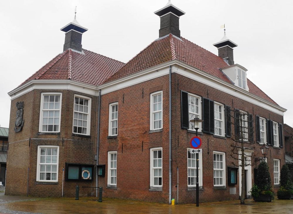 Een bakstenen gebouw met een straatnaambord