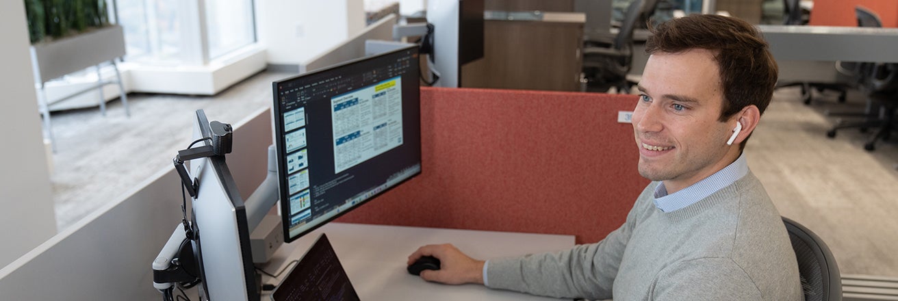 Male employee working with data on computer screen