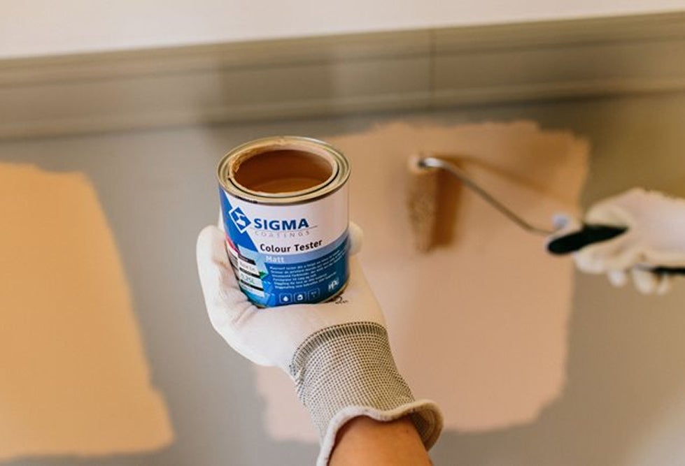 Une main tenant un pot de peinture