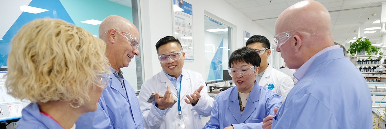 Tim Knavish discussing with PPG employees in laboratory