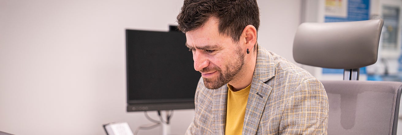 Male employee in office working on laptop