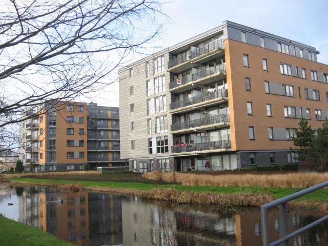 Een gebouw met een vijver op de achtergrond