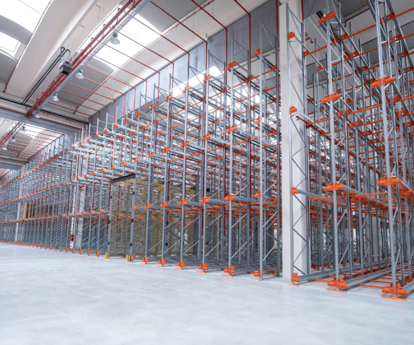 Gray and orange interior shelving and racking in an empty warehouse space