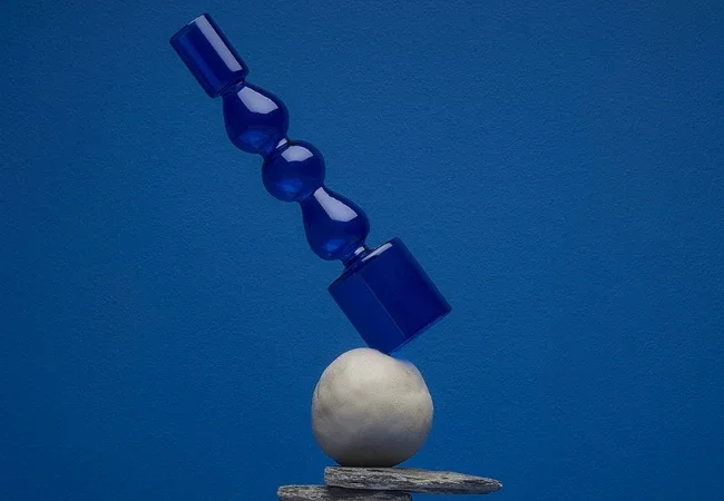 Un objet en verre bleu en équilibre sur une boule blanche