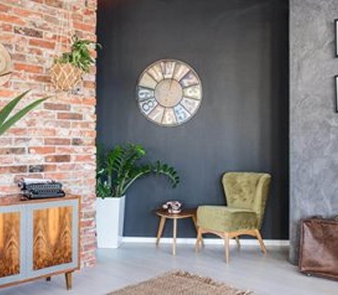 A room with a brick wall and a chair