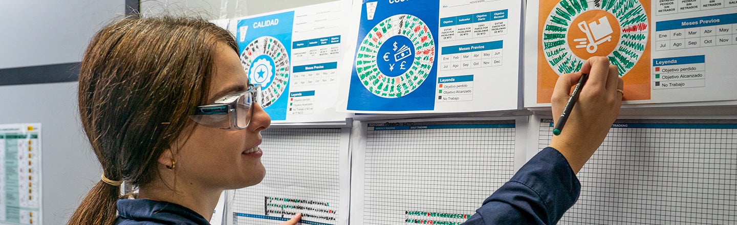 Female worker making notes on data charts