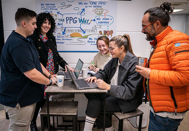 PPG employees discussing data on laptop