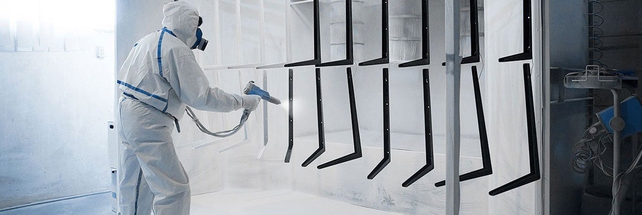 Worker in spray booth coating items