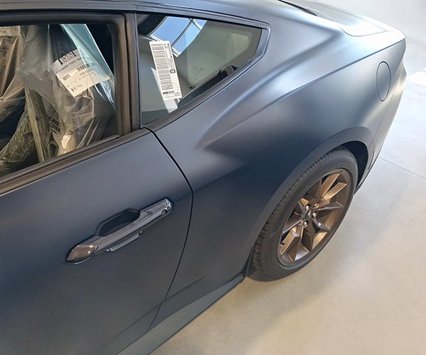 A car with a black paint and clear matte film applied to it