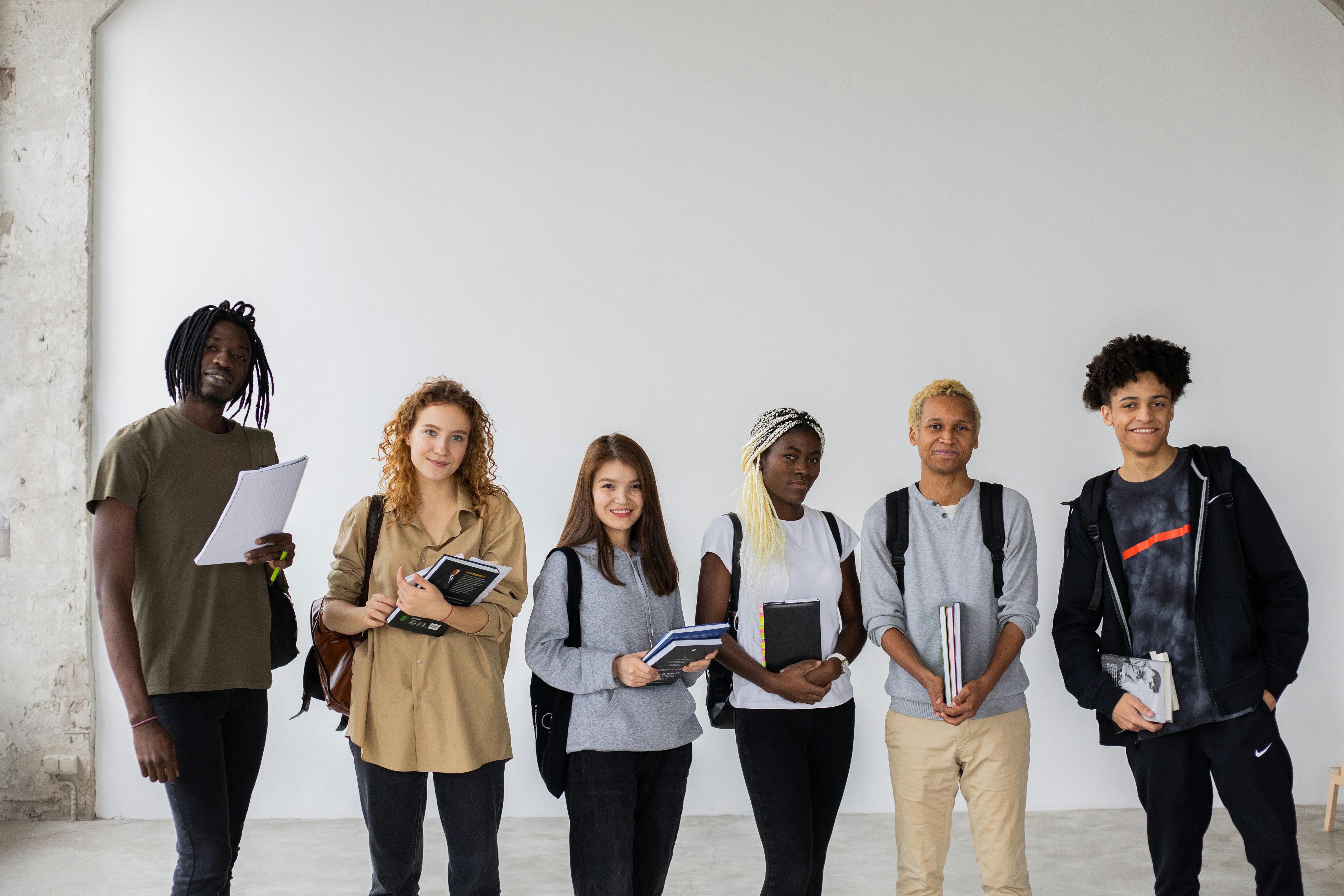 A line of students carrying books and study materials