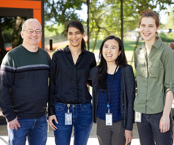 Male and female colleagues smiling outside building