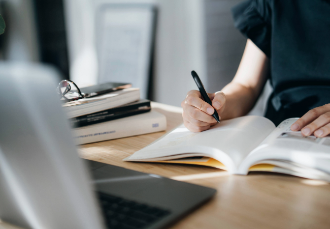 Woman taking notes in book