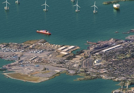 Aerial view of docks, offshore wind farm and city