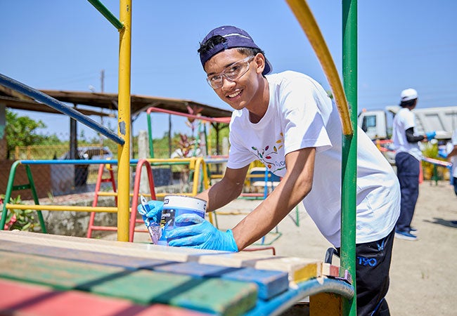 Male volunteer painting as part of Colorful Communities project