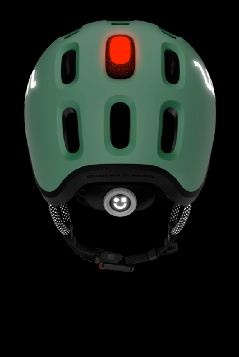 Vue de derrière du casque enfant READY de couleur verte dans le noir avec lampe de casque rouge et éléments réfléchissants
