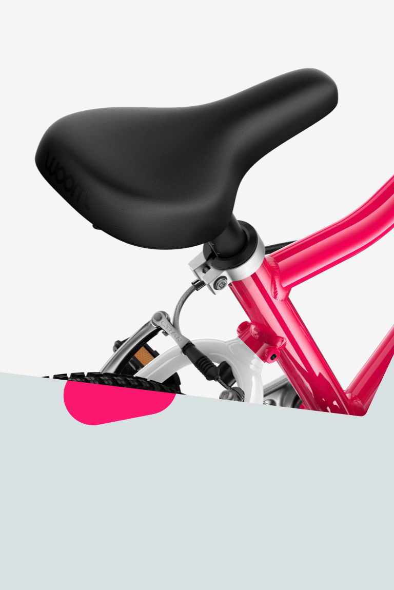 Detailansicht des ergonomisch geformten Fahrradsattels mit glatter Oberfläche an einem pinken woom GO Fahrrad