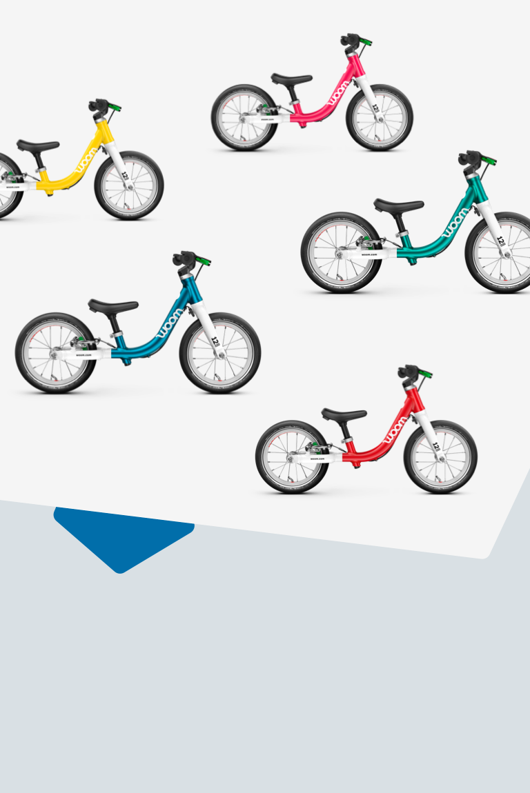 Five woom GO 1 balance bikes in woom red, metallic turquoise, metallic blue, hot pink, vibrant yellow, viewed from the side