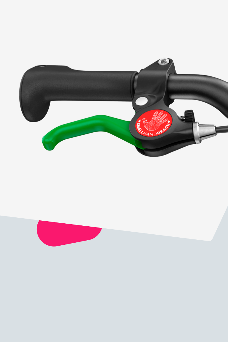 Close-up of the green lever for the rear brake on a woom GO balance bike