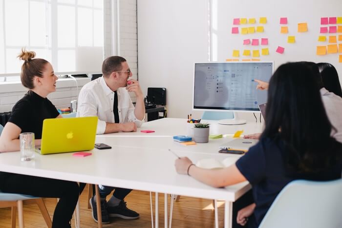 A group of people sitting in the meeting discussing something on the screen