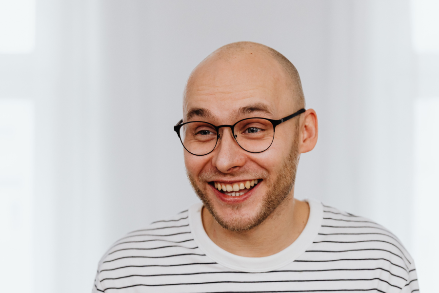 A man wearing glasses and smiling
