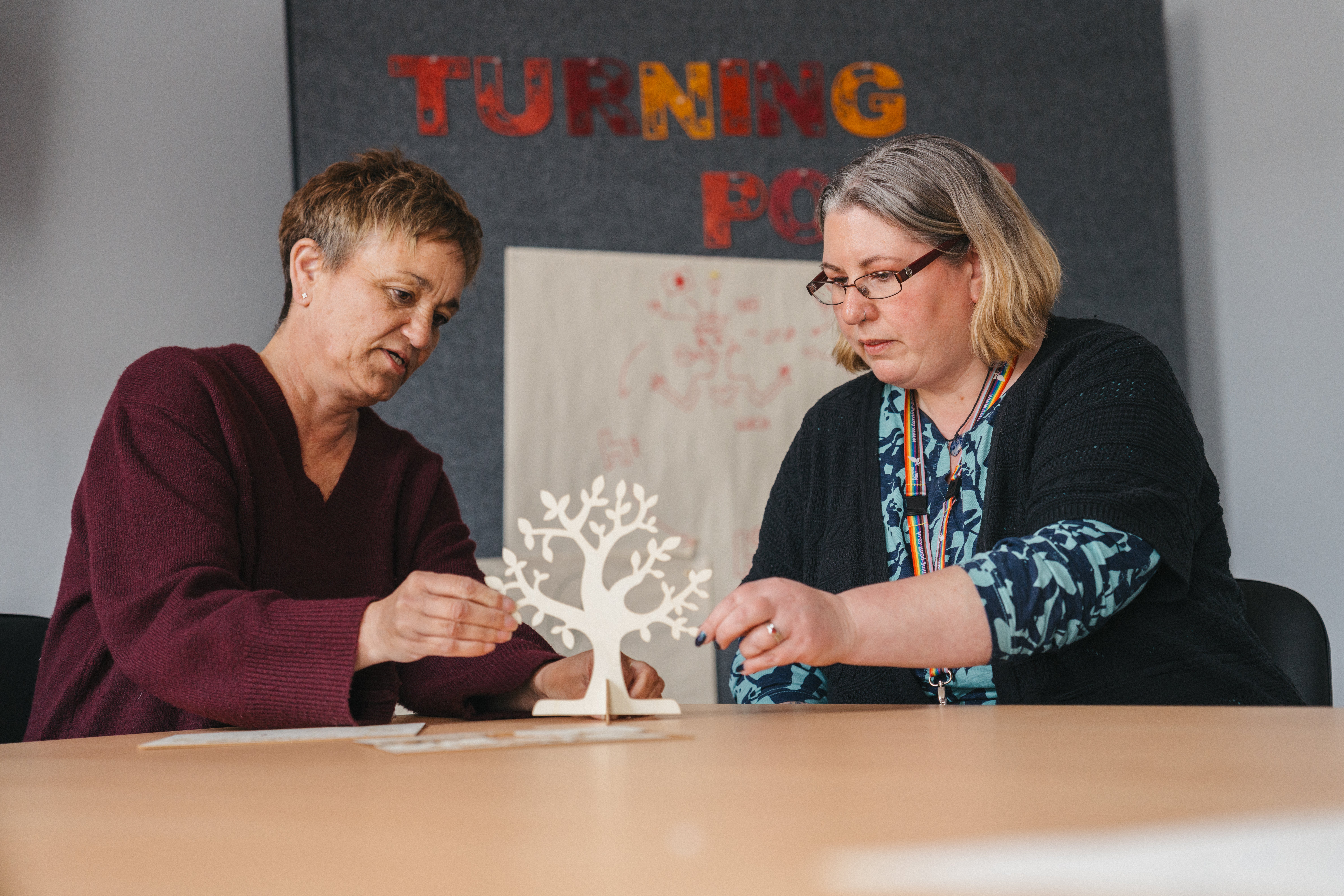 Two ladies sat at a table crafting a recovery tree