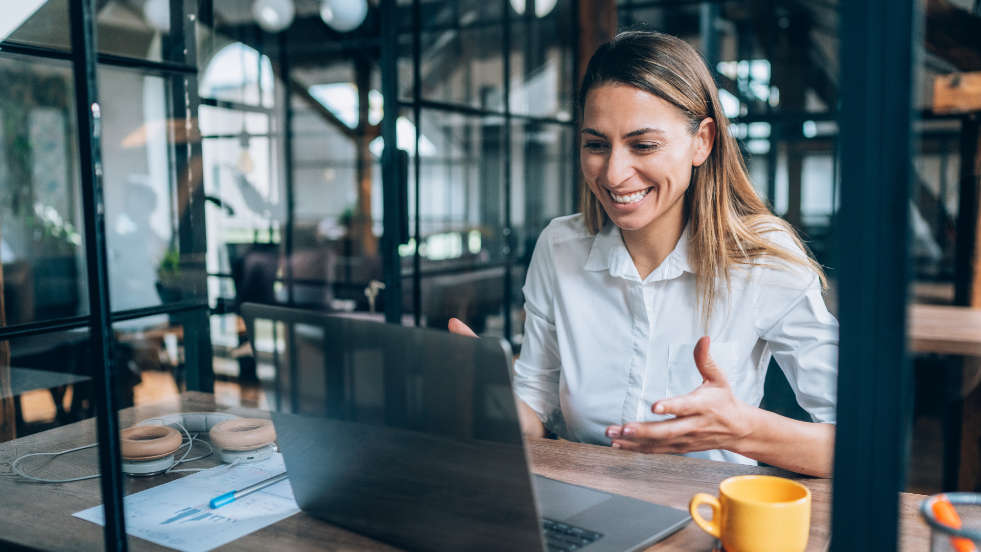 Woman smiling on video call talking to laptop.
