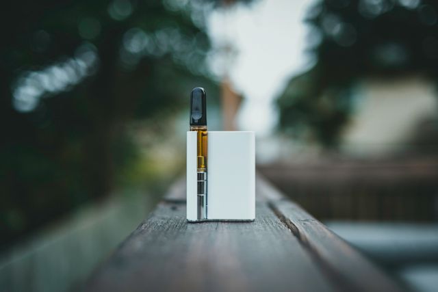 A white and black vape on a wooden surface