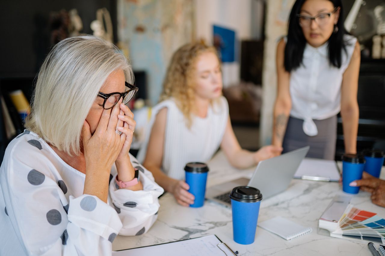 A woman crying at a table with two women in the background