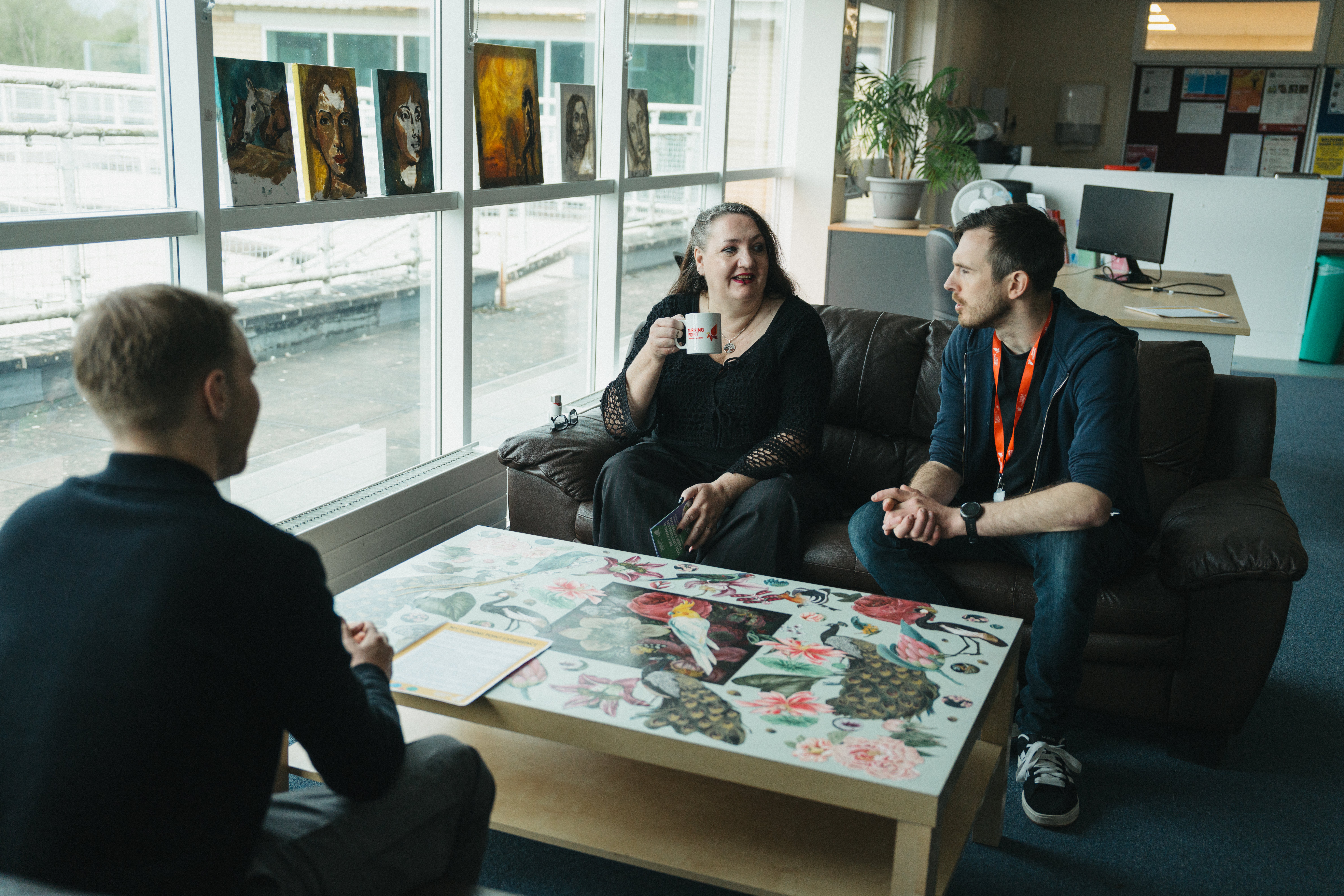 Three people sitting around a table talking