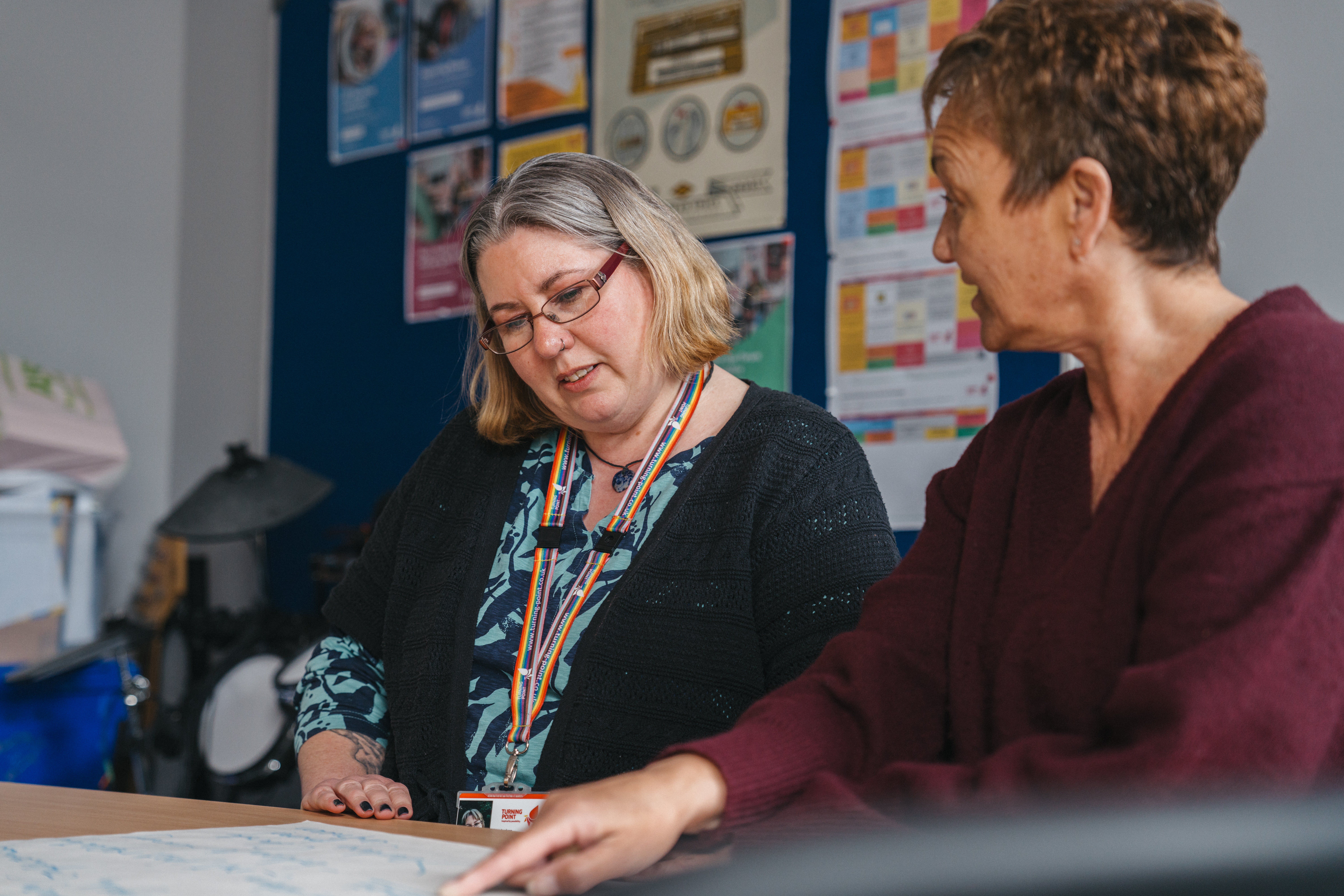 two ladies sitting at a table looking at some paper