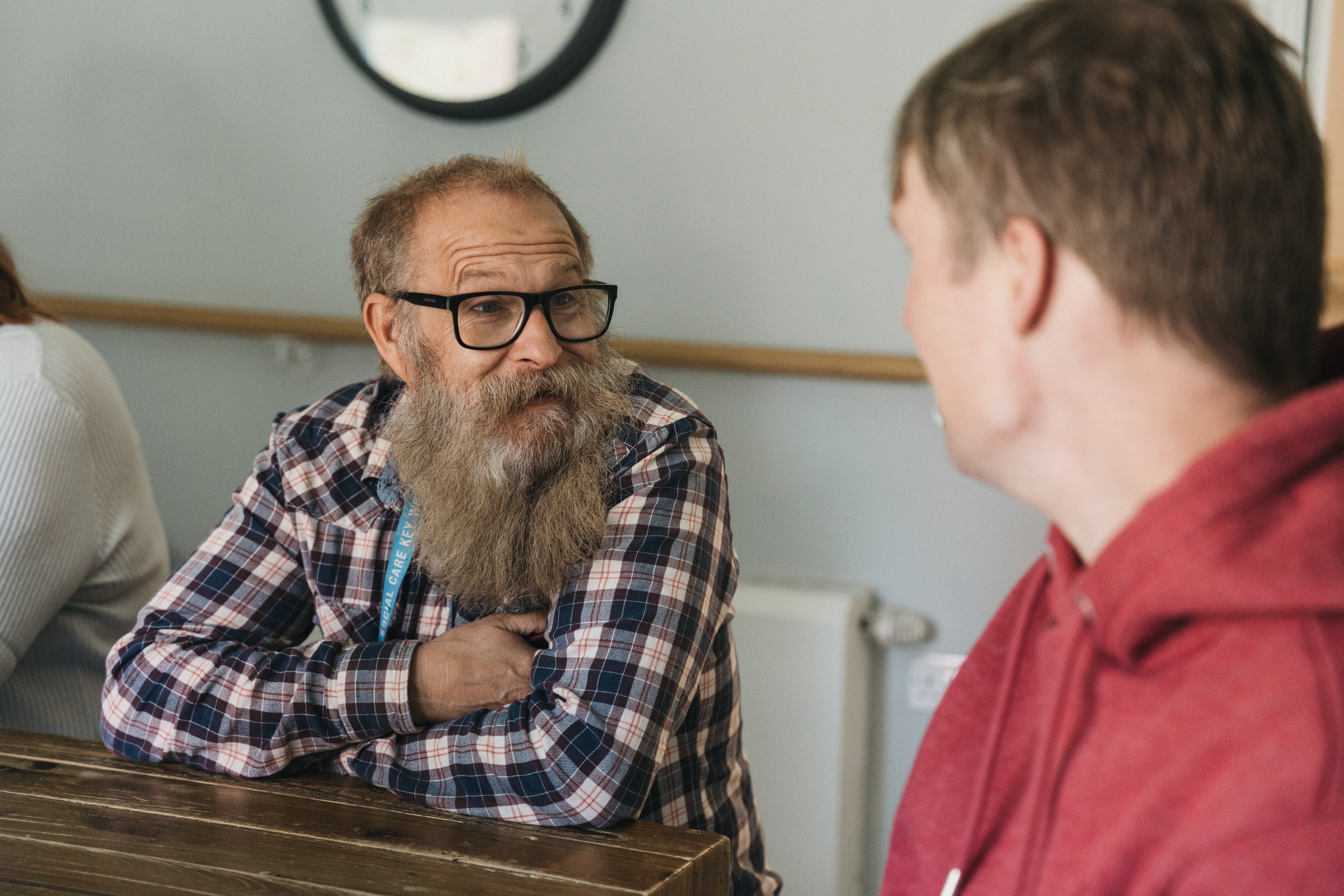 A man with a beard talking to another man