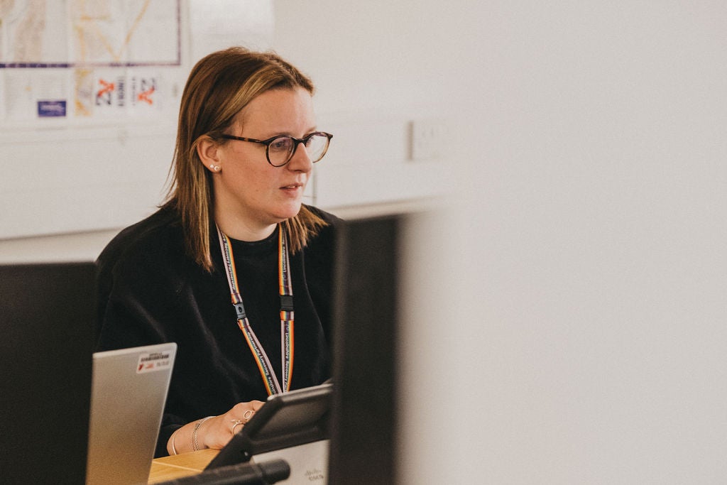A woman sitting at a desk with a laptop