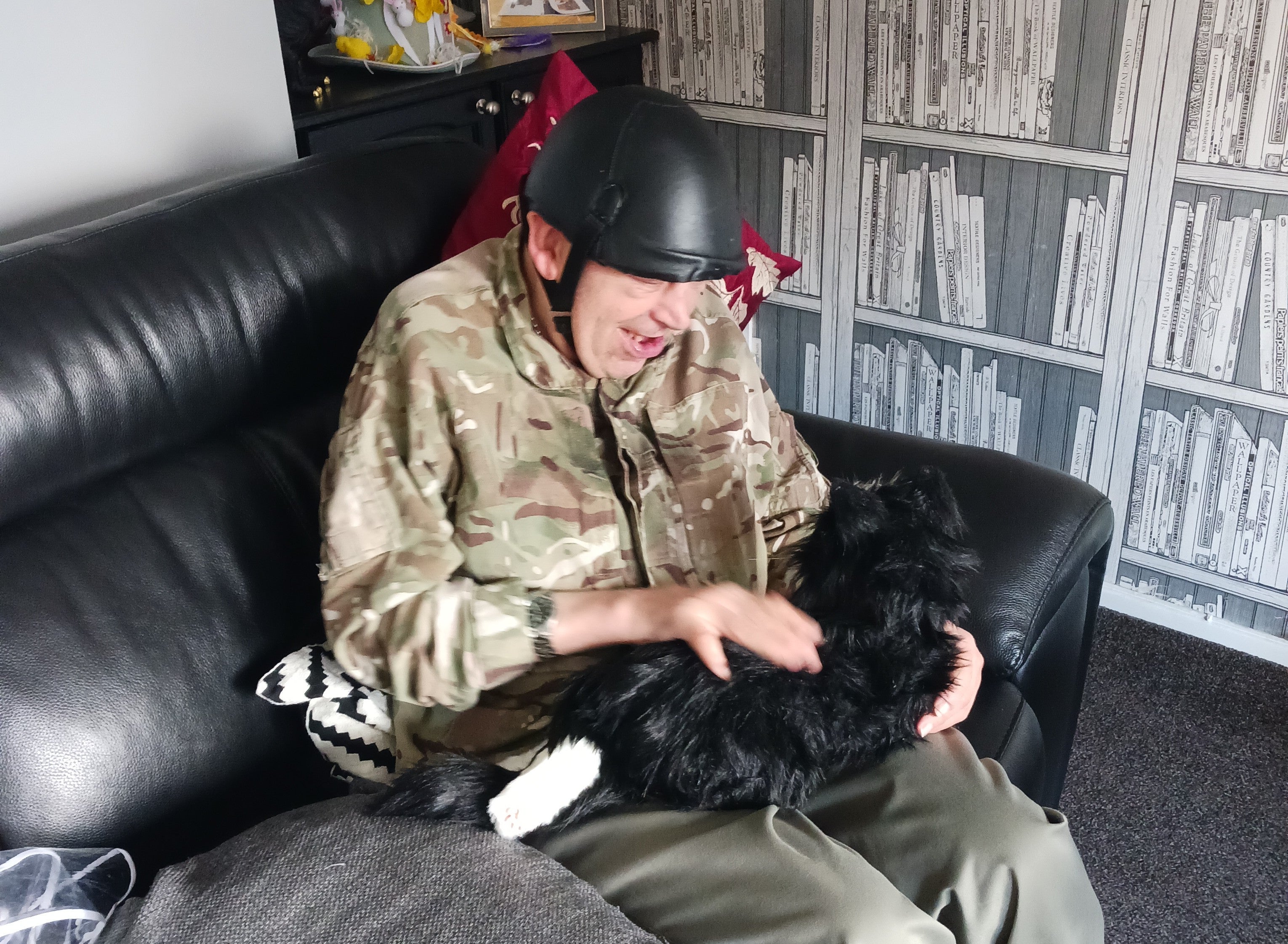 A man in a helmet holding a dog