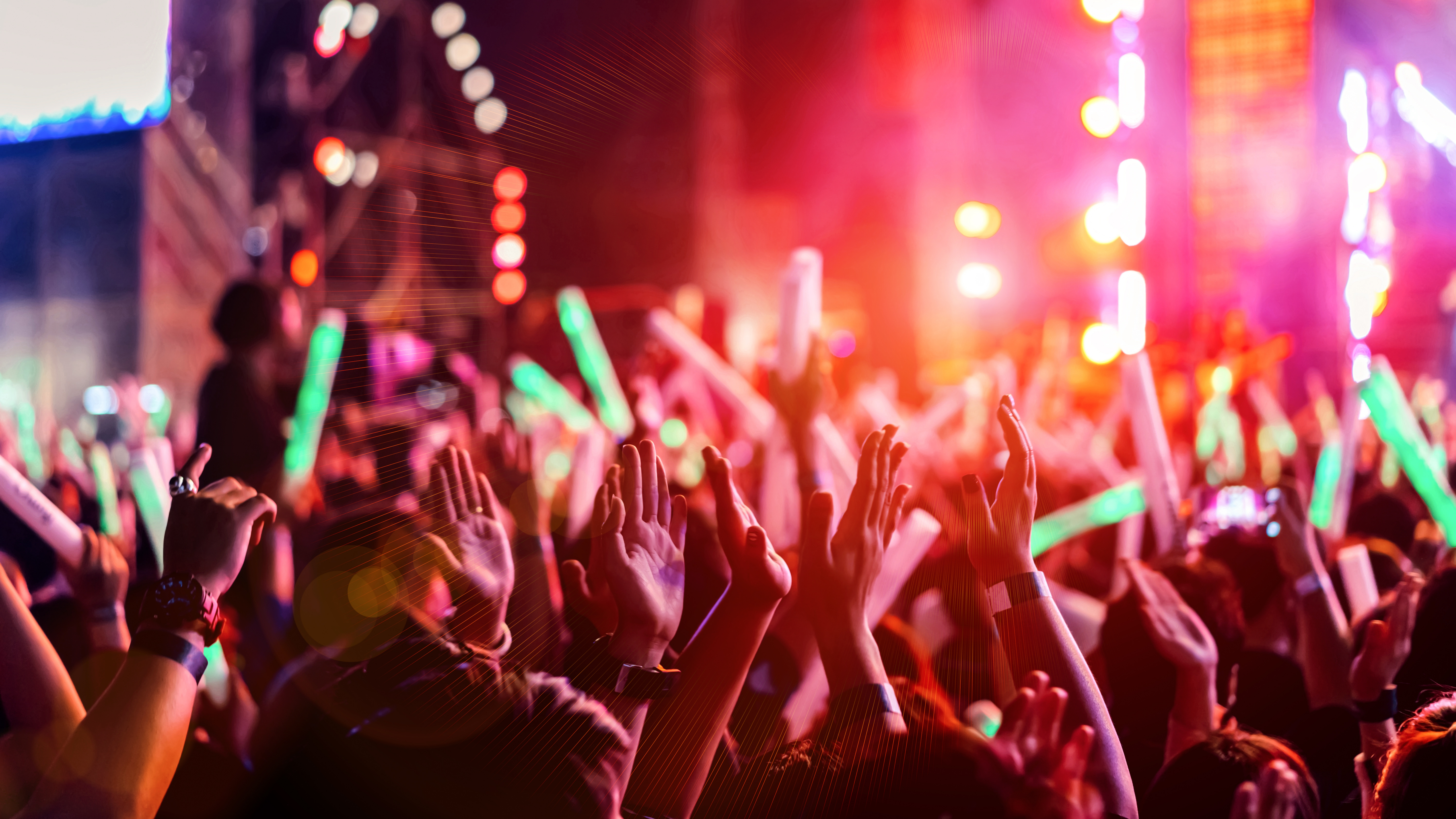 people dancing at a festival with glow sticks