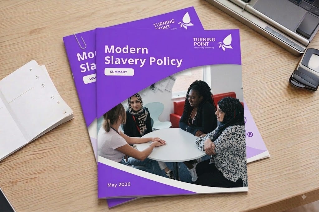 A stack of 'Modern Slavery Policy' documents on a desk.