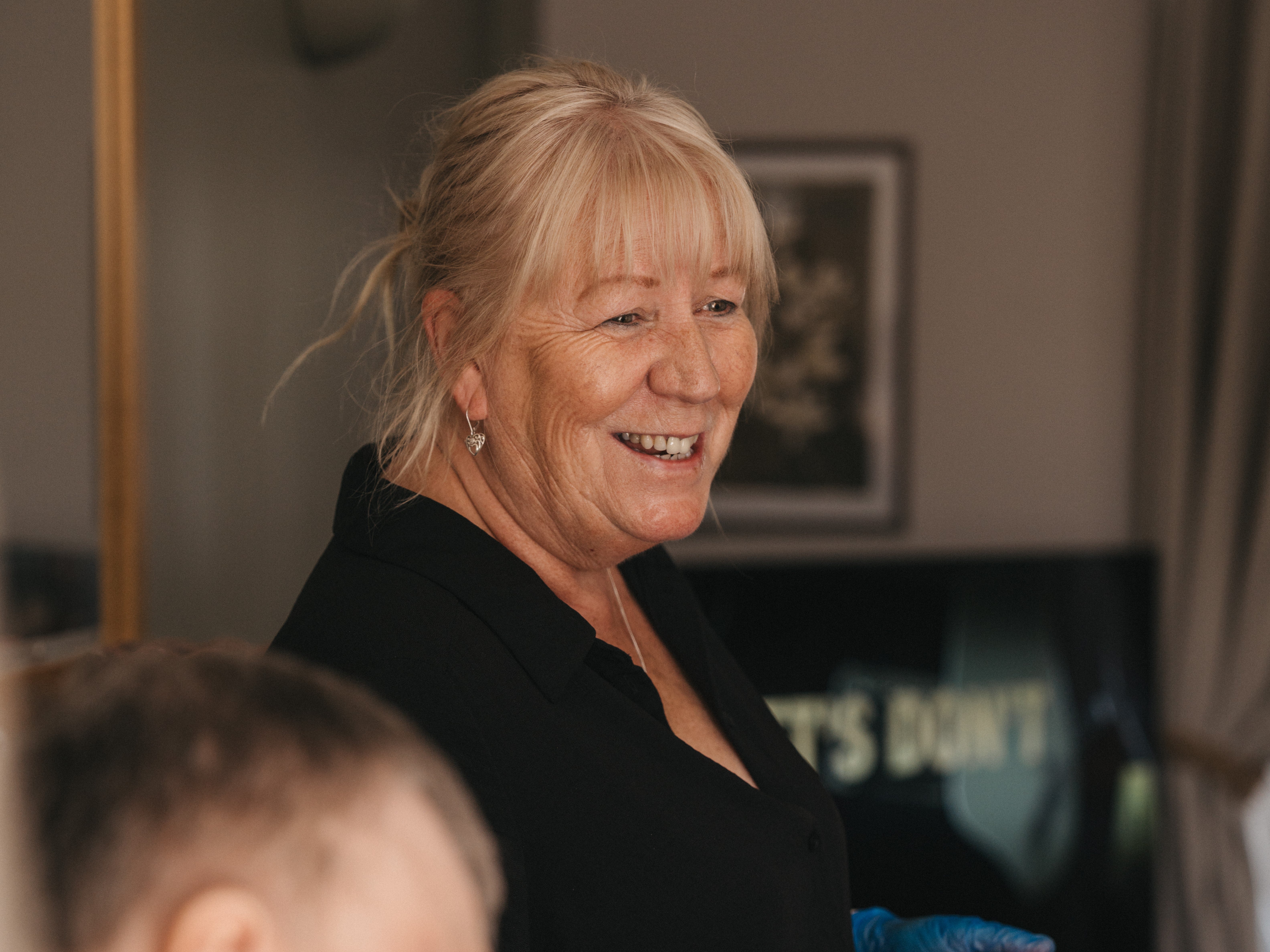 A smiling woman in a black shirt