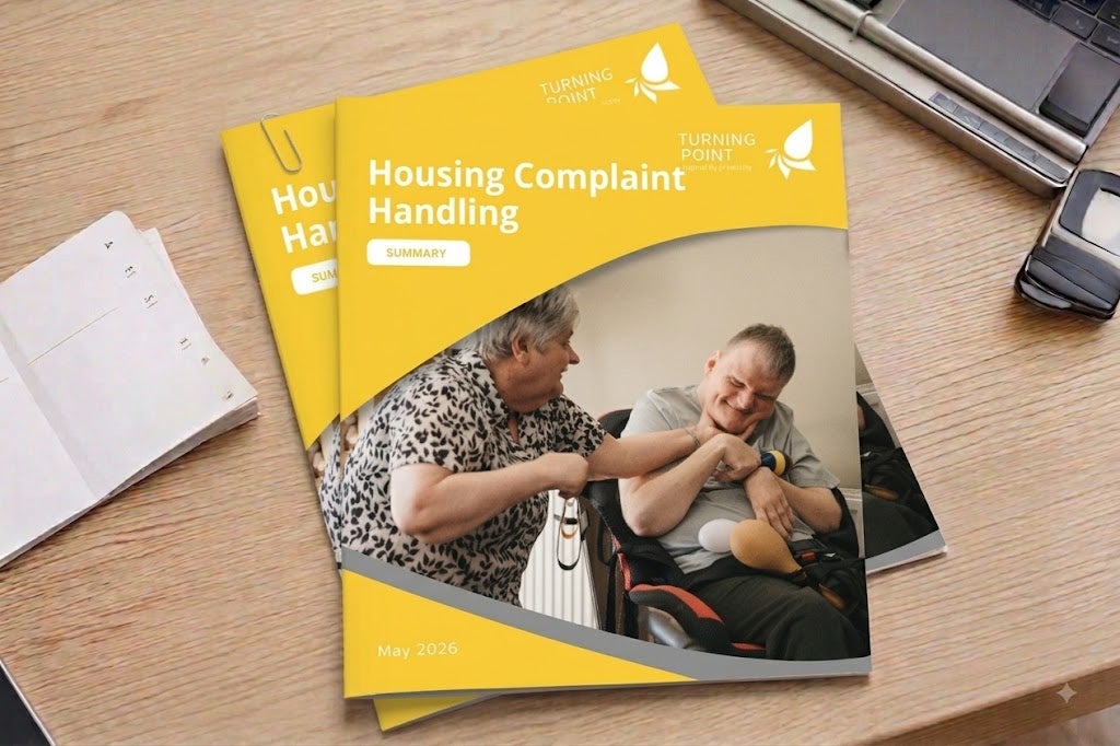 A stack of 'Housing Complaint Handling' policies on a desk.